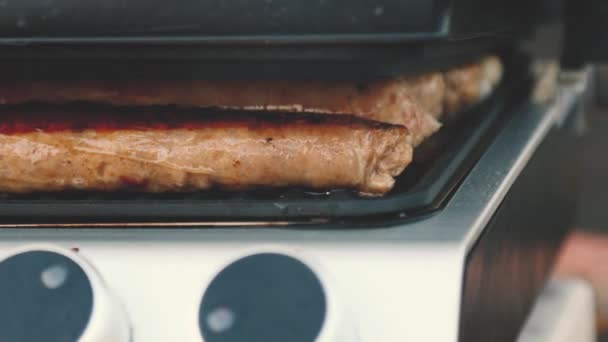 Churrasco com salsichas de fogo na grelha em um piquenique ao ar livre . — Vídeo de Stock