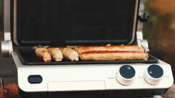 Барбекю с огненными сосисками на гриле на пикнике на открытом воздухе . — стоковое видео