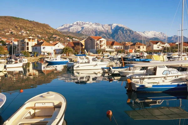 Рыбацкие лодки в Марина Калиманж города Тиват с заснеженной горой Ловчен на заднем плане в солнечный зимний день. Черногория — стоковое фото