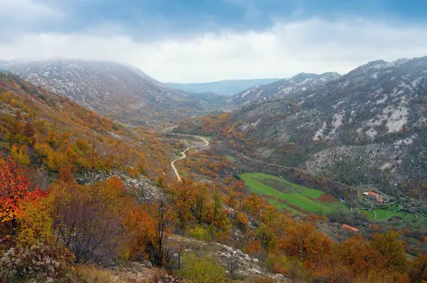 Sonbahar dağ görünümü ile küçük bir köy ve bir yol. Bosna Hersek — Stok fotoğraf