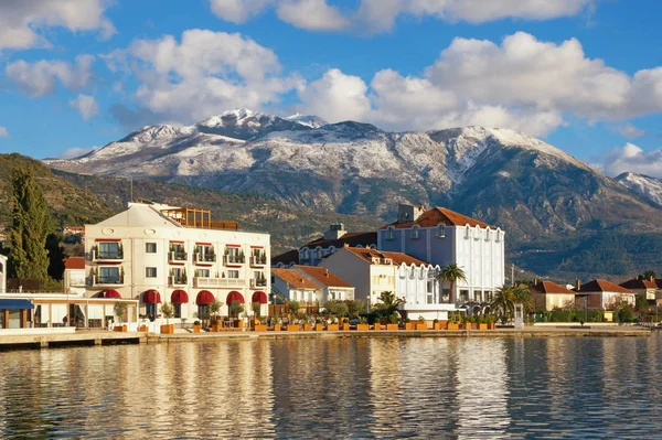 Besneeuwde bergen en groene badplaats. Montenegro, winter. Weergave van Dijk van Tivat stad en besneeuwde Lovcen berg — Stockfoto