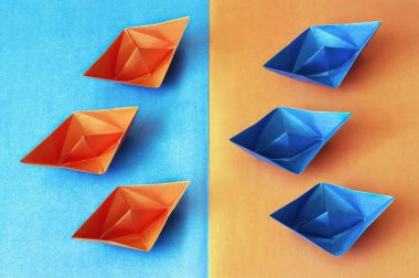 Origami. Mavi ve turuncu kağıt tekne zıt bir arka plan üzerinde