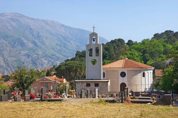 Iglesia con cementerio contra montañas. Montenegro, iglesia ortodoxa de San Pedro de Cetinje (Svetog Petra Cetinjskog) en Prcanj ciudad — Foto de Stock
