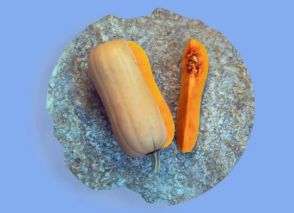 Fatia de abóbora e abóbora na placa de corte de pedra isolada no fundo roxo — Fotografia de Stock