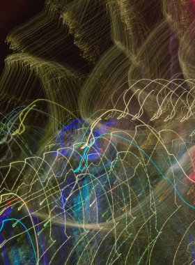 Hareket - soyut arkaplan. Karanlığın içindeki ritmik renkli çizgiler. Gece hareket eden arabanın yol ışıkları. Yavaş deklanşör hızı