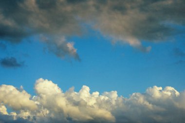 Beyaz ve koyu bulutlar arasındaki mavi gökyüzü şeridi, arka plan. Cirrocumulus bulutları