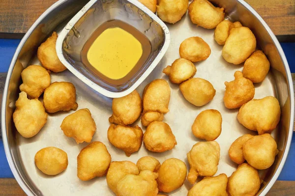 Balkan cuisine. Priganice (small fried pies, donuts) with bowl of honey on rustic tray