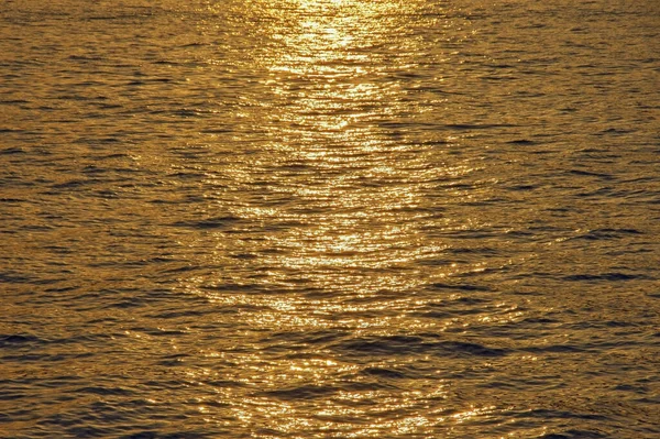 Piękne Tło Kolorze Złotym Naturalna Faktura Wody Morskiej Oświetlona Zachodzącym — Zdjęcie stockowe