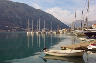 Kotor şehrindeki liman. Kış günü su üstünde yatlar ve balıkçı tekneleri. Karadağ, Adriyatik Denizi, Kotor Körfezi 