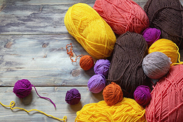 Концепция хобби, вязание. Яркие разноцветные палочки шерсти на деревенском столе. Свободное место для текста
