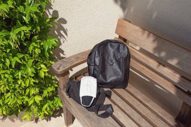 Güneşli yaz gününde sırt çantası ve maske. Bir salgından sonra normal hayata yolculuğun başlangıcı, konsept