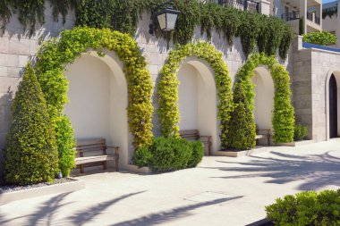 Rahatlamak için rahat bir yer. Güneşli bahar gününde Tivat şehrinin setinde park bankları. Karadağ