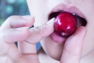 bir kadın bahçede kiraz yemek