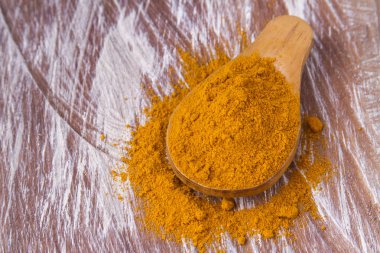 Ahşap arka planda kökler ve zerdeçal tozu (curcuma longa)