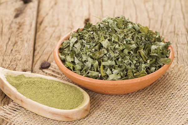 Stof en moringa bladeren op houten achtergrond — Stockfoto