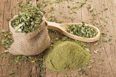 Ahşap arka plan toz ve moringa yapraklarda