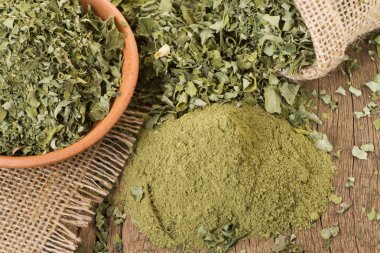Ahşap arka plan toz ve moringa yapraklarda