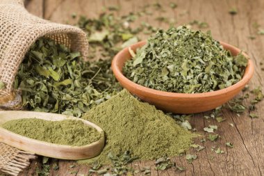 Ahşap arka plan toz ve moringa yapraklarda