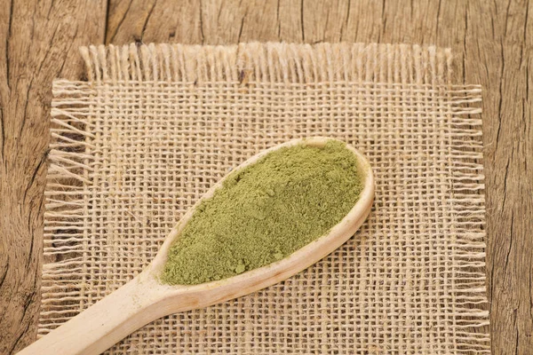 Polvo y hojas de moringa sobre fondo de madera —  Fotos de Stock