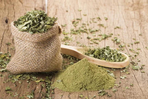 Stof en moringa bladeren op houten achtergrond — Stockfoto