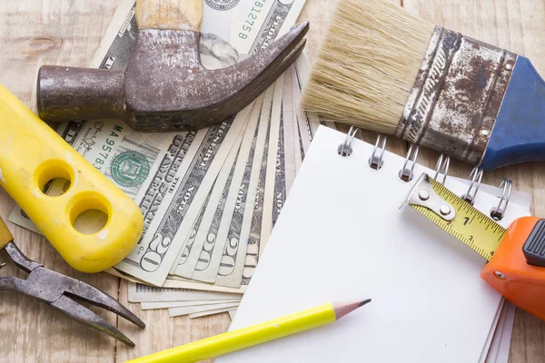 Defter, hesap makinesi ve araçlar ahşap arka plan üzerinde remodeling bütçe yapmak için