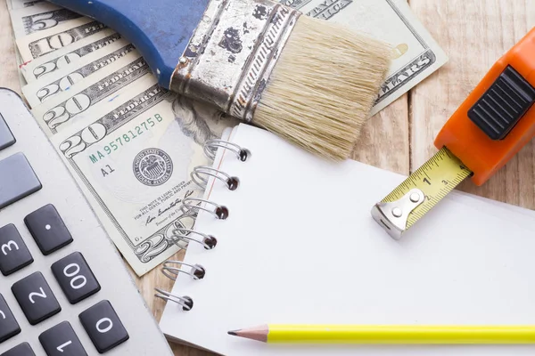 Defter, hesap makinesi ve araçlar ahşap arka plan üzerinde remodeling bütçe yapmak için