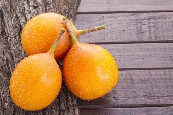 Granadilla, frutas tropicales sobre fondo de madera (Passiflora ligularis ) — Foto de Stock