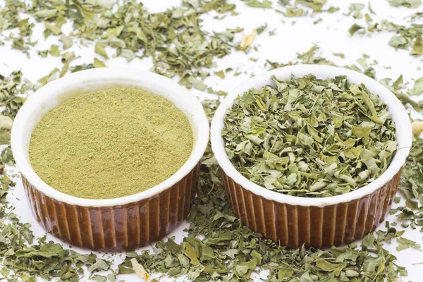 Stof en moringa bladeren op houten achtergrond (Moringa oleifera) — Stockfoto