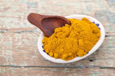 Kökleri ve ahşap arka plan (uzun curcuma üzerinde zerdeçal tozu)