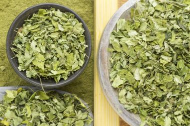 Yaprakları ve moringa tozu ahşap arka plan (moringa olifera üzerinde