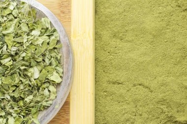 Yaprakları ve moringa tozu ahşap arka plan (moringa olifera üzerinde