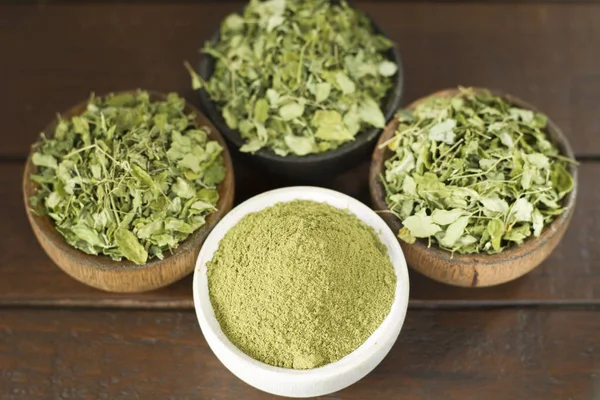 Bladeren en moringa poeder op hout (moringa oleifera) — Stockfoto