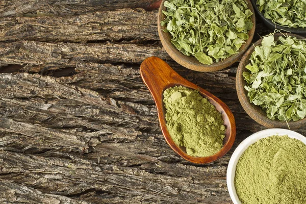 Bladeren en moringa poeder op hout (moringa oleifera) — Stockfoto