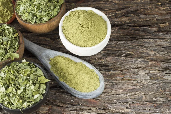 Folhas e moringa em pó sobre madeira (moringa oleifera ) — Fotografia de Stock