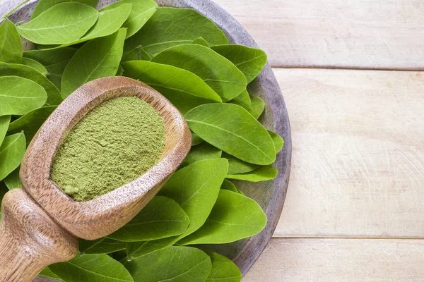 Folhas e moringa em pó sobre madeira (moringa oleifera ) — Fotografia de Stock