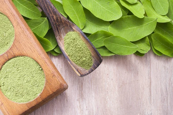 Bladeren en moringa poeder op hout (moringa oleifera) — Stockfoto