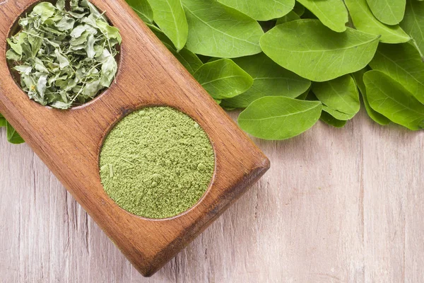 Folhas e moringa em pó sobre madeira (moringa oleifera ) — Fotografia de Stock