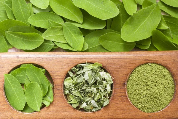 Folhas e moringa em pó sobre madeira (moringa oleifera ) — Fotografia de Stock