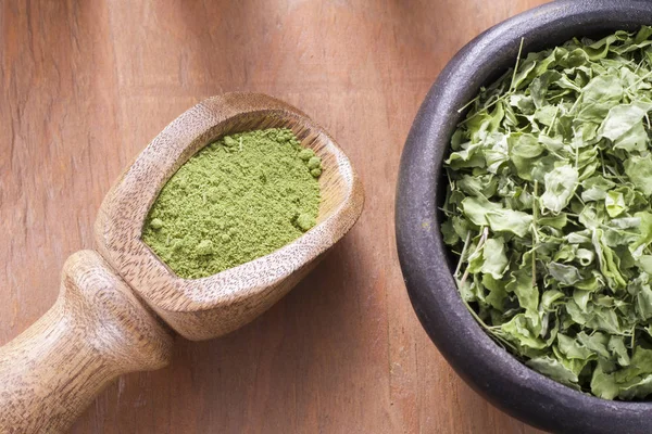 Bladeren en moringa poeder op hout (moringa oleifera) — Stockfoto