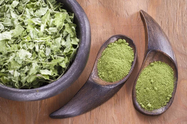 Bladeren en moringa poeder op hout (moringa oleifera) — Stockfoto