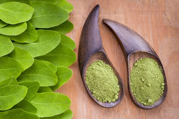 Folhas e moringa em pó sobre madeira (moringa oleifera ) — Fotografia de Stock