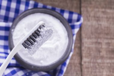 Baking soda and brush on wooden table clipart