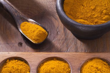Kase ve ahşap masa (curcuma longa kaşık zerdeçal tozu)