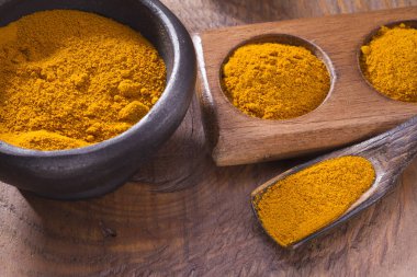 Kase ve ahşap masa (curcuma longa kaşık zerdeçal tozu)