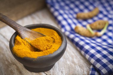 Kase ve ahşap masa (curcuma longa kaşık zerdeçal tozu)