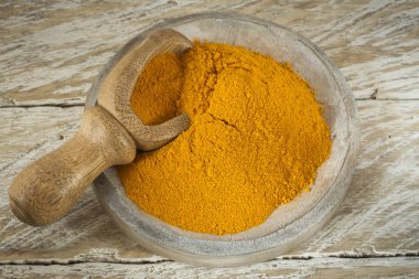 Kase ve ahşap masa (curcuma longa kaşık zerdeçal tozu)