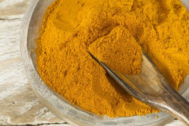 Kase ve ahşap masa (curcuma longa kaşık zerdeçal tozu)