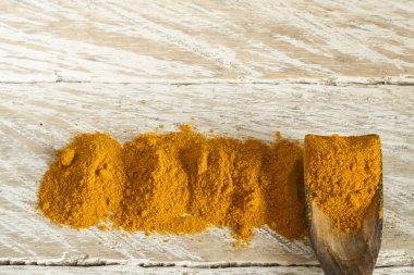 Kase ve ahşap masa (curcuma longa kaşık zerdeçal tozu)