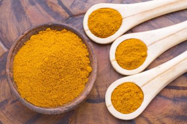 Ahşap arka plan (curcuma longa üzerine kaşıkla zerdeçal tozu)