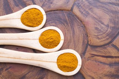 Ahşap arka plan (curcuma longa üzerine kaşıkla zerdeçal tozu)